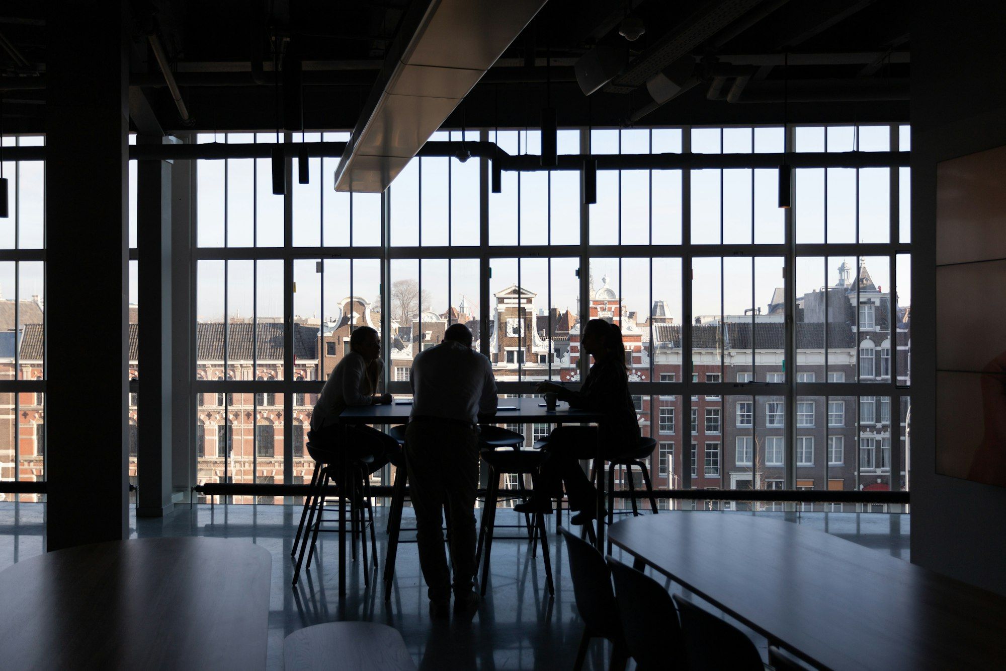 Leaders meeting against a bright window wall